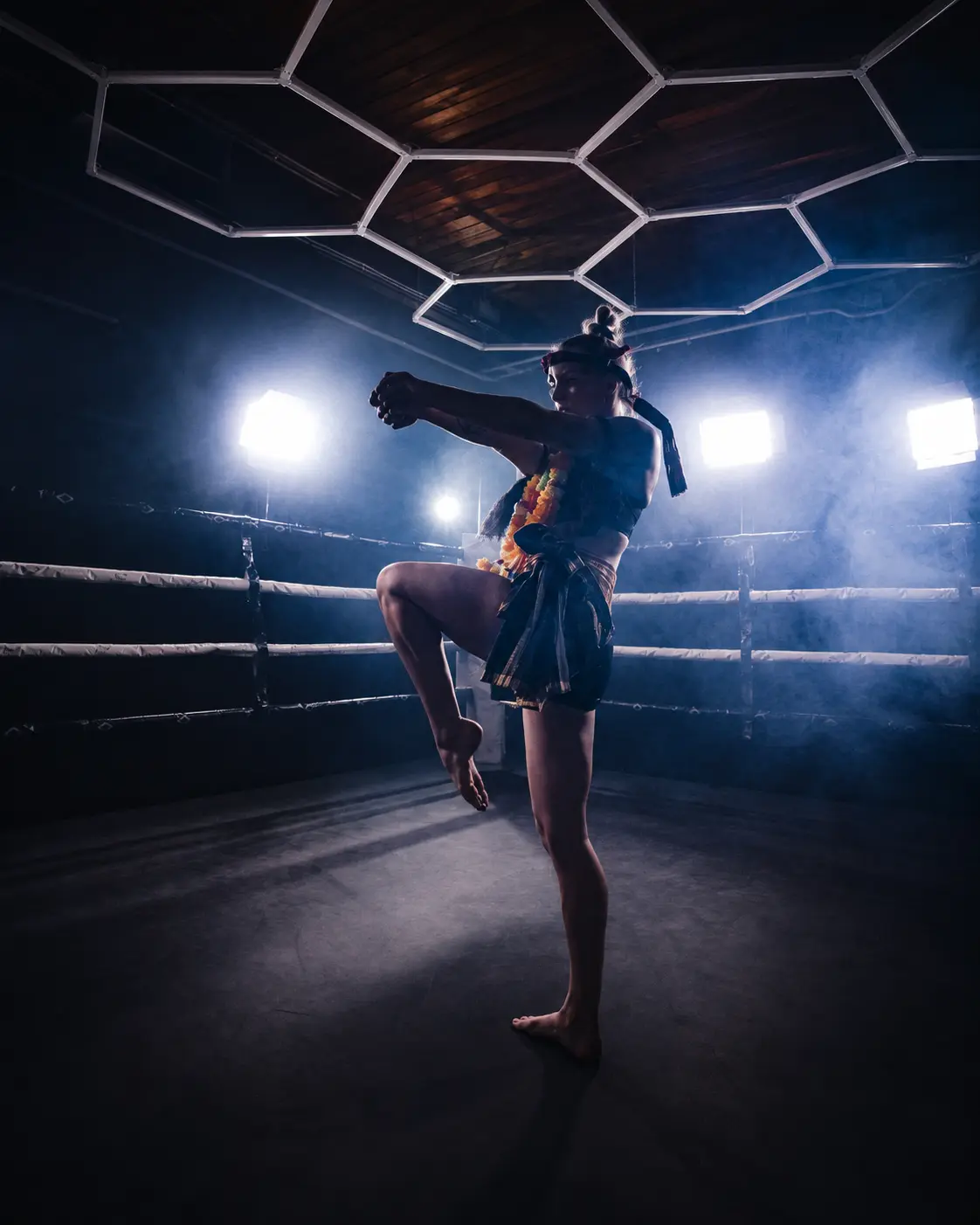 A fighter performing Wai Kru Ram in a dark ring